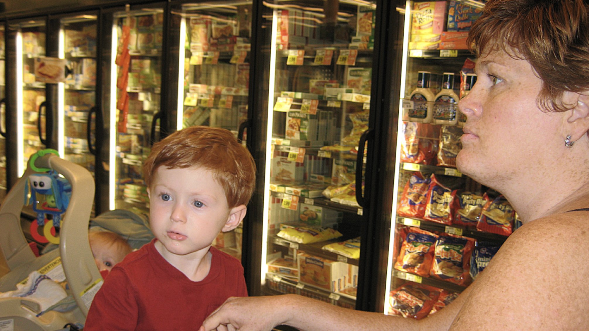 Mom grocery shopping with children